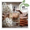 Flakon perfum z kwiatami i drewnem na tle jasnym.