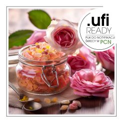 Szklany słoik wypełniony kolorowymi granulkami zapachowymi, otoczony różowymi różami na drewnianym stole-AF70 8831